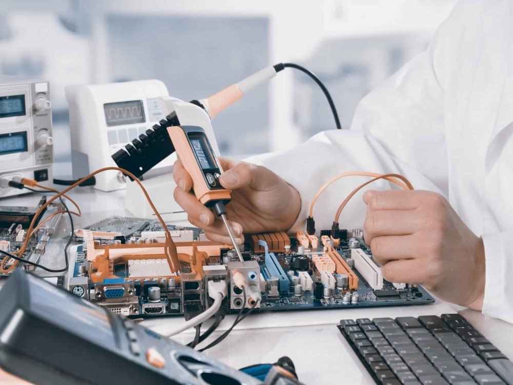 Repairman fixes electronic equipment in service center